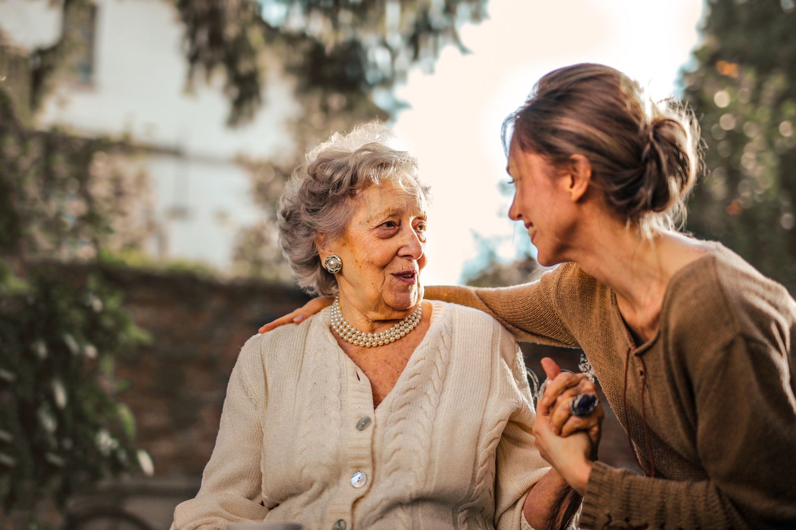 Caregiver supporting an older adult outdoors before a medical appointment